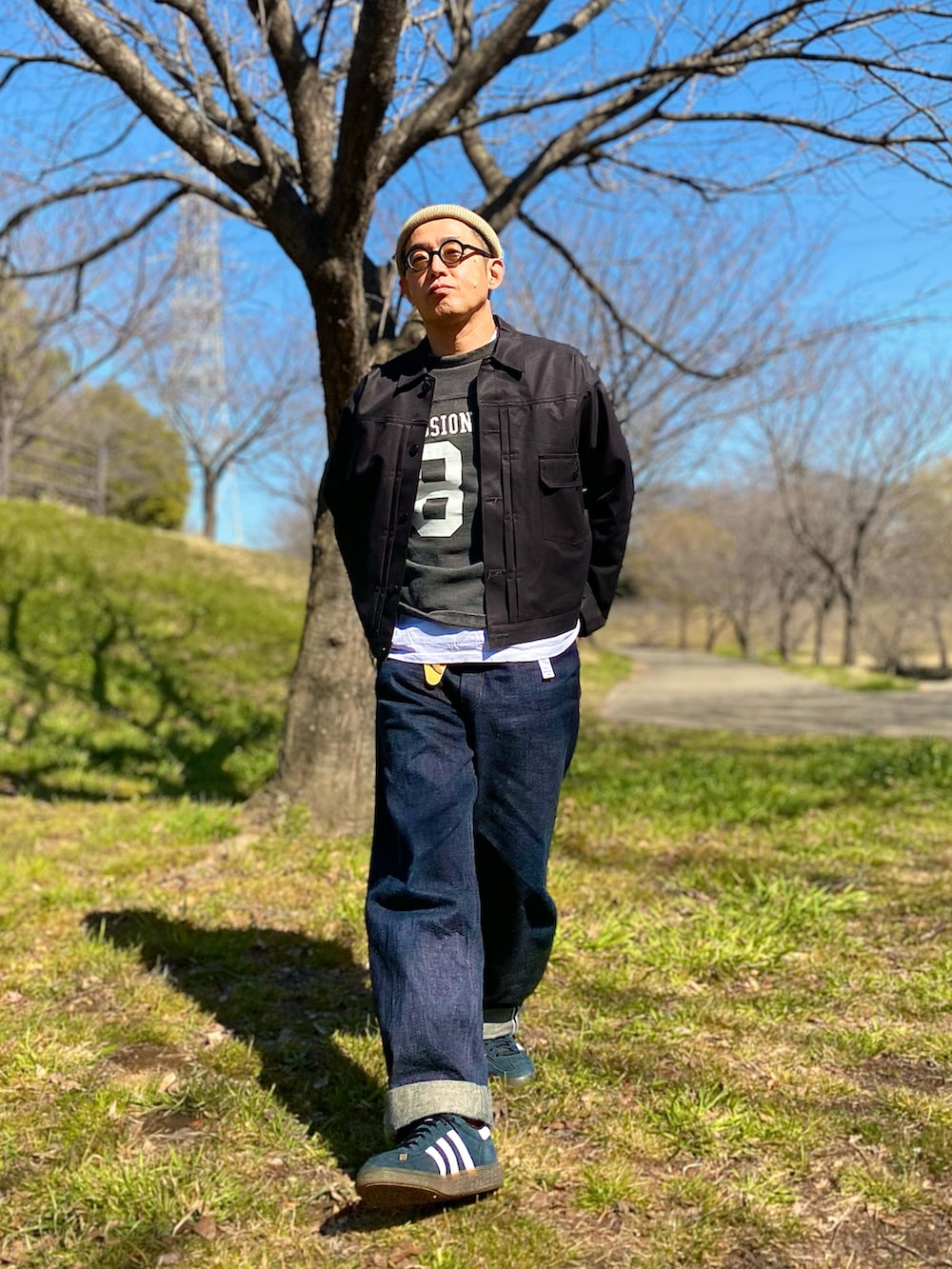 ブラック系のその他アウター、ブルー系のデニムパンツ、ブラック系のスニーカーを着用したメンズの春コーディネートの2枚目の写真