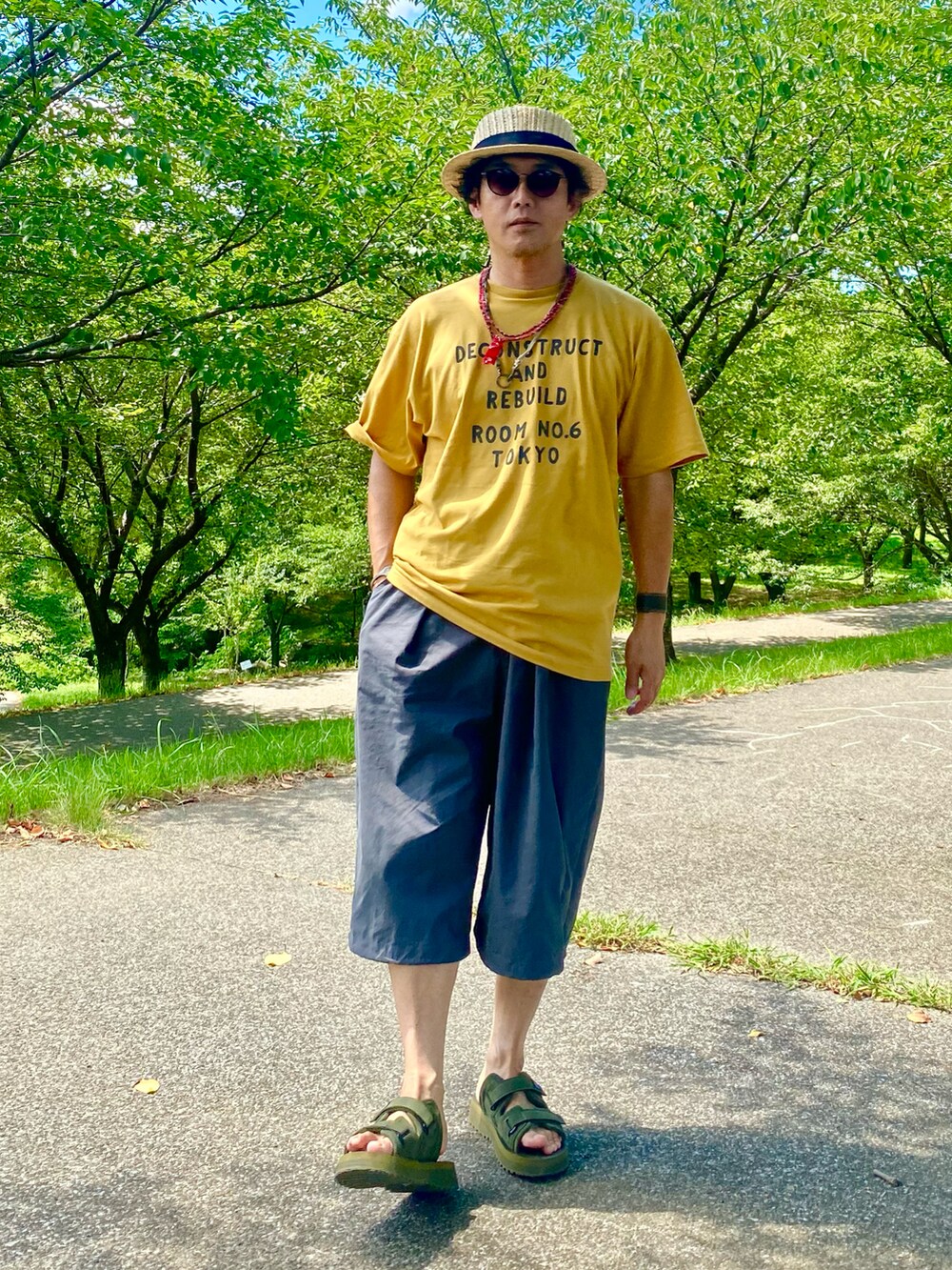 グリーン系のサンダル、ベージュ系のハットを着用したメンズの夏コーディネートの4枚目の写真