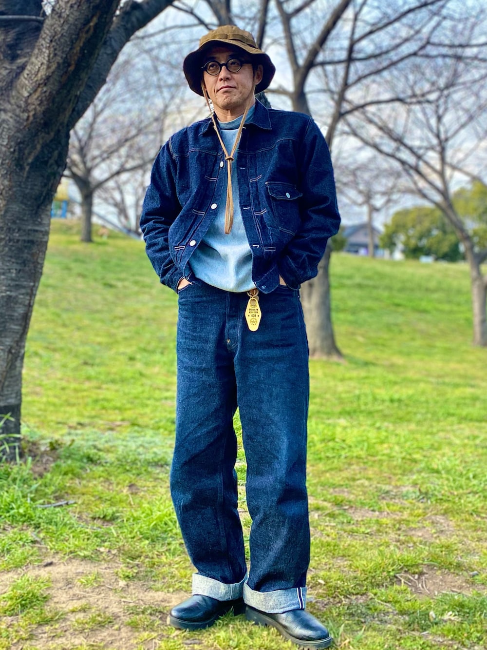 ブルー系のデニムジャケット、グレー系のスウェット、ブルー系のデニムパンツを着用したメンズの春コーディネートの2枚目の写真