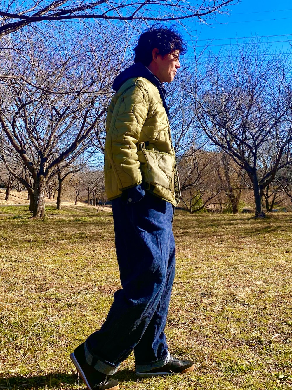 ブルー系のカバーオール、グリーン系のミリタリージャケットを着用したメンズの冬コーディネートの3枚目の写真