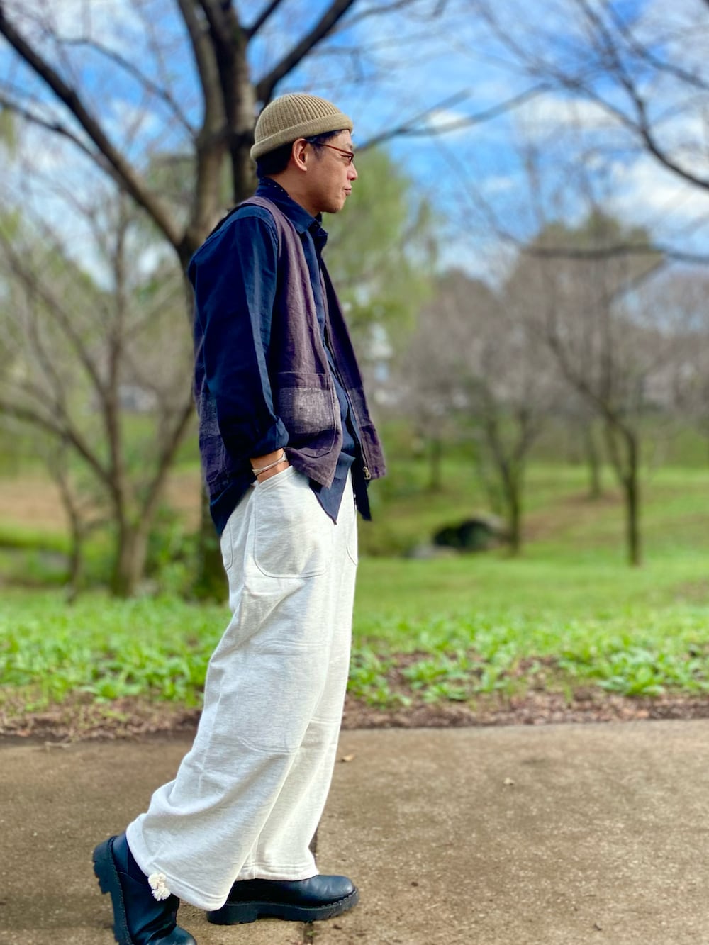 ホワイト系のスウェットパンツ、ブラック系のベスト、ホワイト系のニットキャップ/ビーニーを着用したメンズの秋コーディネートの3枚目の写真