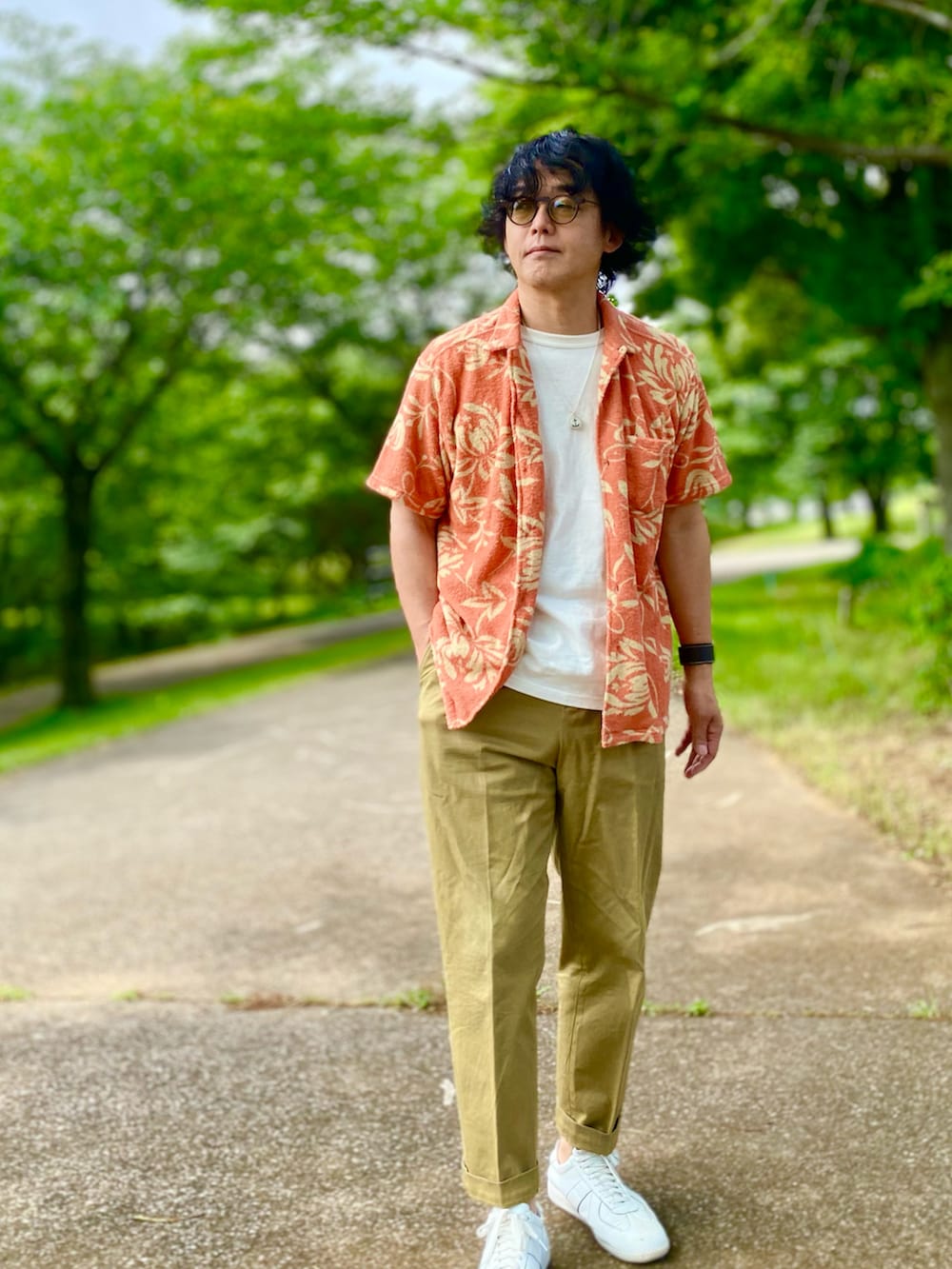 ベージュ系のチノパンツ、オレンジ系のシャツ/ブラウス、ホワイト系のTシャツ/カットソーを着用したメンズの夏コーディネートの4枚目の写真