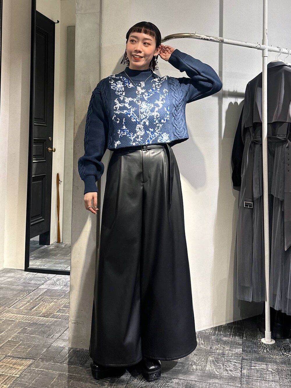 ブルー系のニット/セーター、ブラック系のその他パンツ、ブラック系のブーツを着用したレディースの冬コーディネートの8枚目の写真