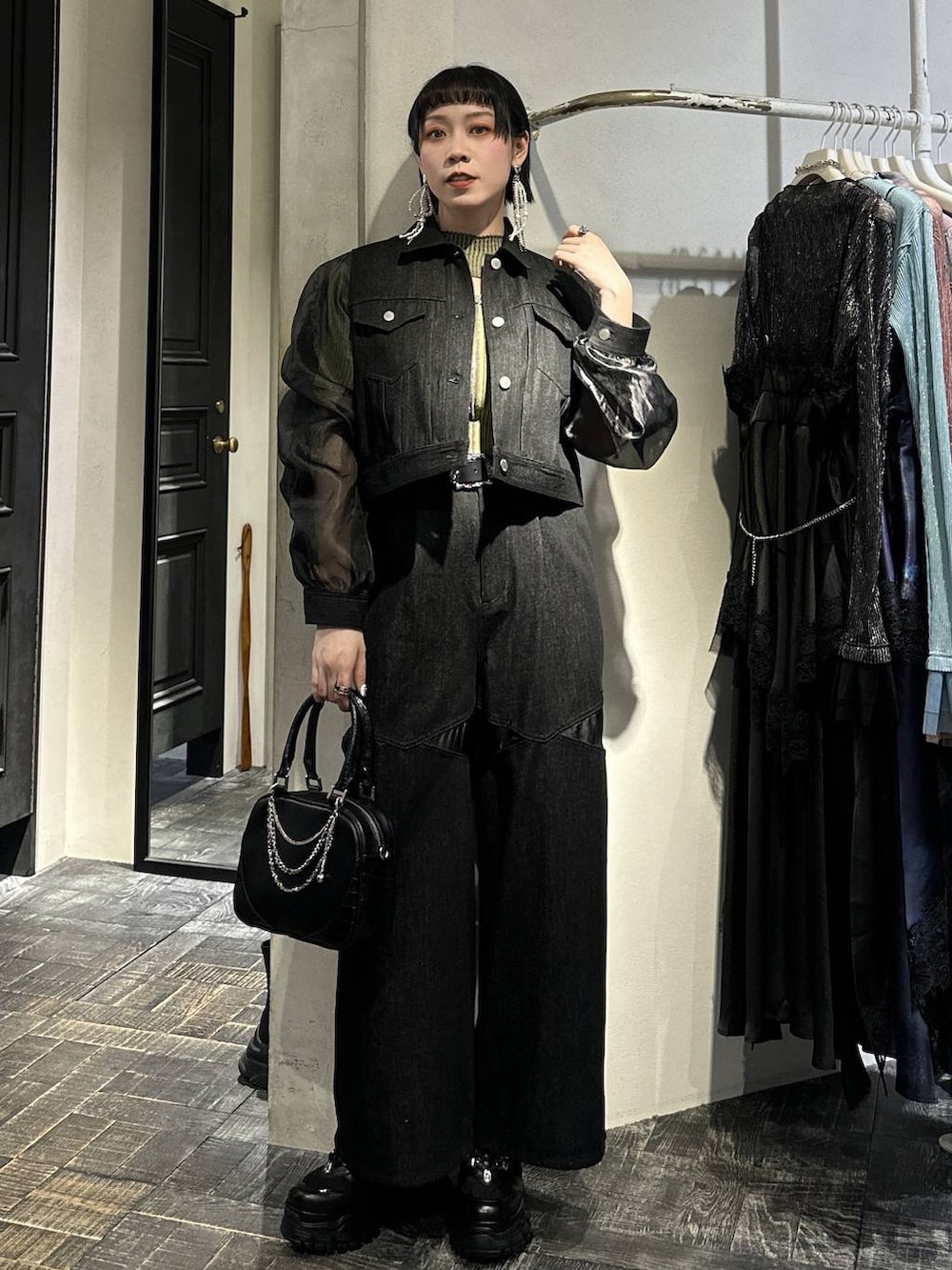 ブラック系のスニーカー、ブラック系のブルゾン、ブラック系のデニムパンツを着用したレディースの春コーディネートの3枚目の写真