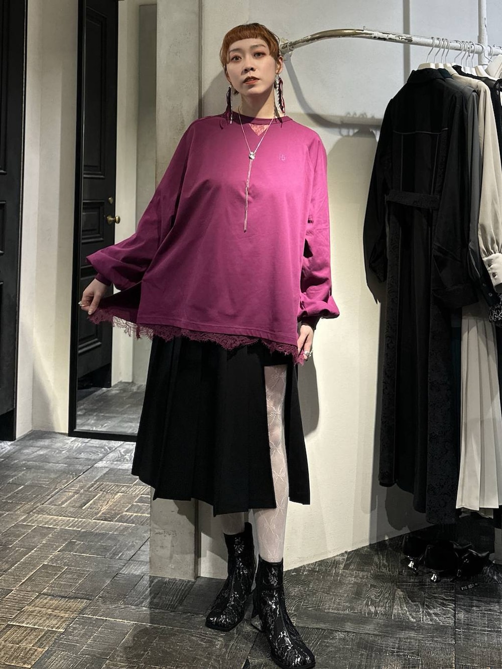 ブラック系のブーツ、ブラック系のスカート、ピンク系のTシャツ/カットソーを着用したレディースの冬コーディネートの3枚目の写真