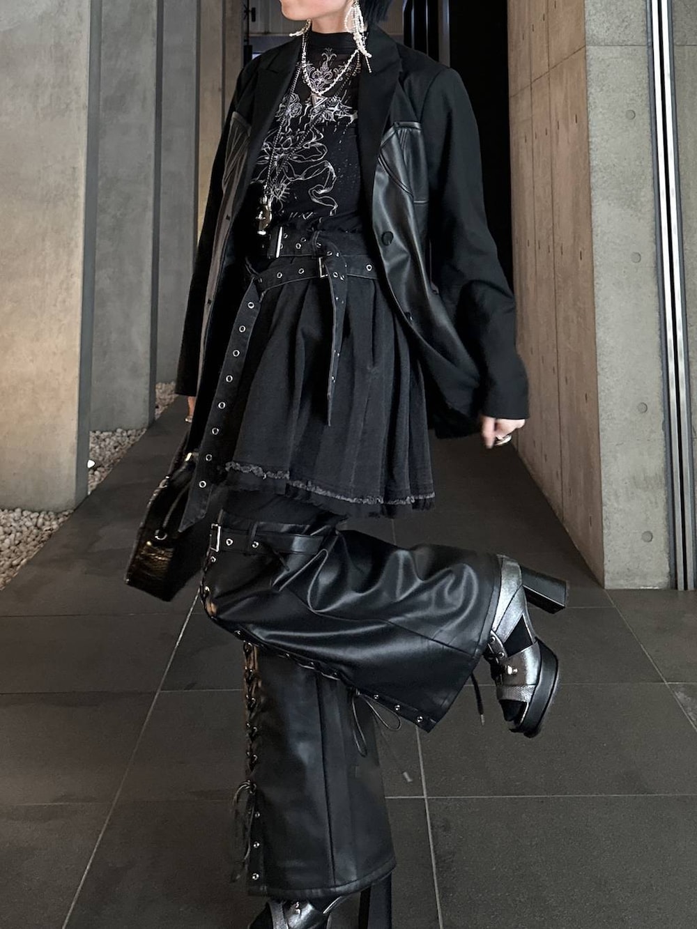 シルバー系のブーツ、ブラック系のショルダーバッグ、シルバー系のネックレスを着用したレディースの春コーディネートの6枚目の写真