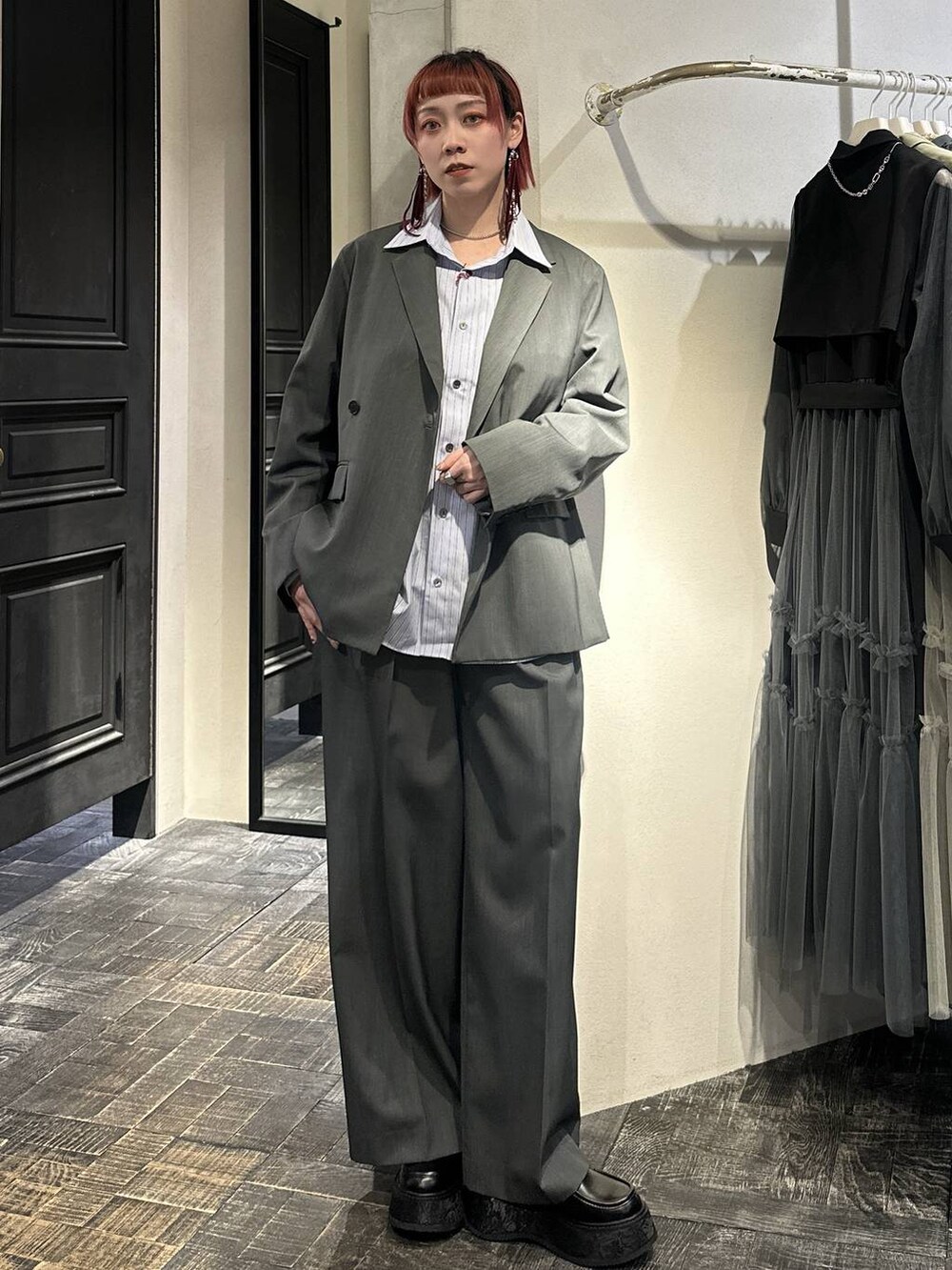 ブラック系のローファー、グレー系のスラックス、シルバー系のネックレスを着用したレディースの春コーディネートの5枚目の写真