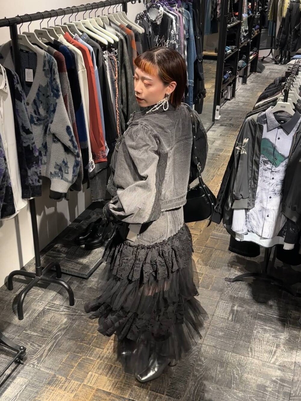 シルバー系のブーツ、ブラック系のニット/セーター、ブラック系のショルダーバッグを着用したレディースの秋コーディネートの4枚目の写真