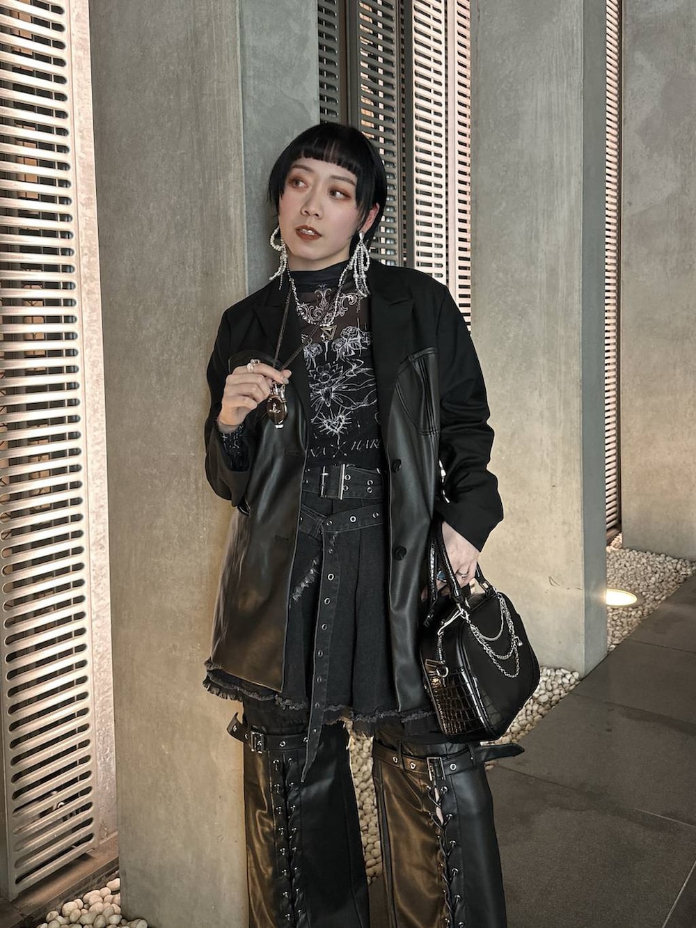 シルバー系のブーツ、ブラック系のショルダーバッグ、シルバー系のネックレスを着用したレディースの春コーディネートの9枚目の写真