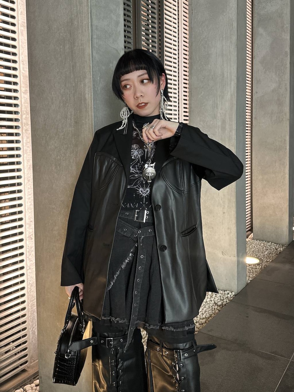 シルバー系のブーツ、ブラック系のショルダーバッグ、シルバー系のネックレスを着用したレディースの春コーディネートの8枚目の写真