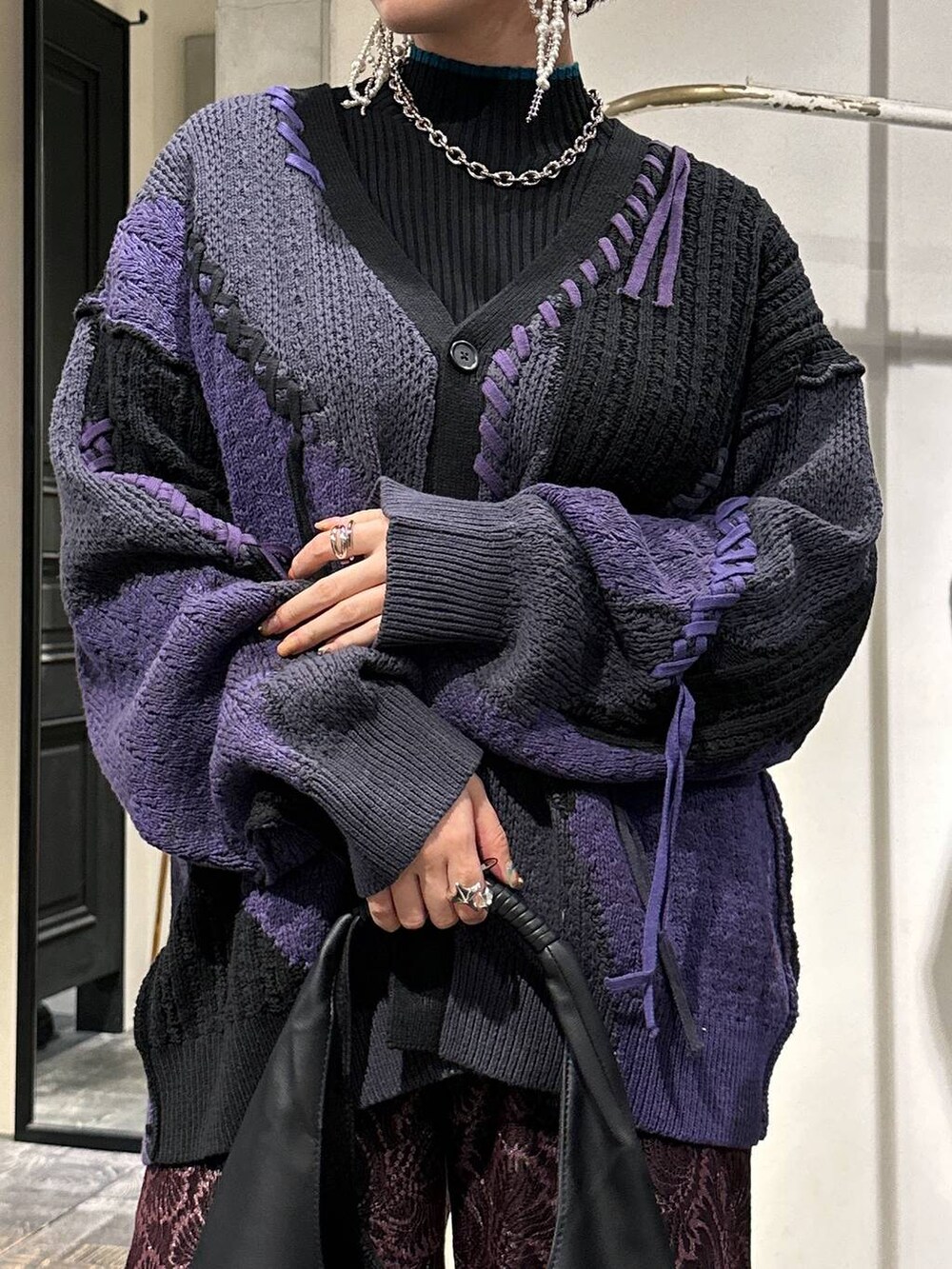 ブラック系のカーディガン/ボレロ、ブラック系のトートバッグ、ブラック系のブーツを着用したレディースの秋コーディネートの4枚目の写真