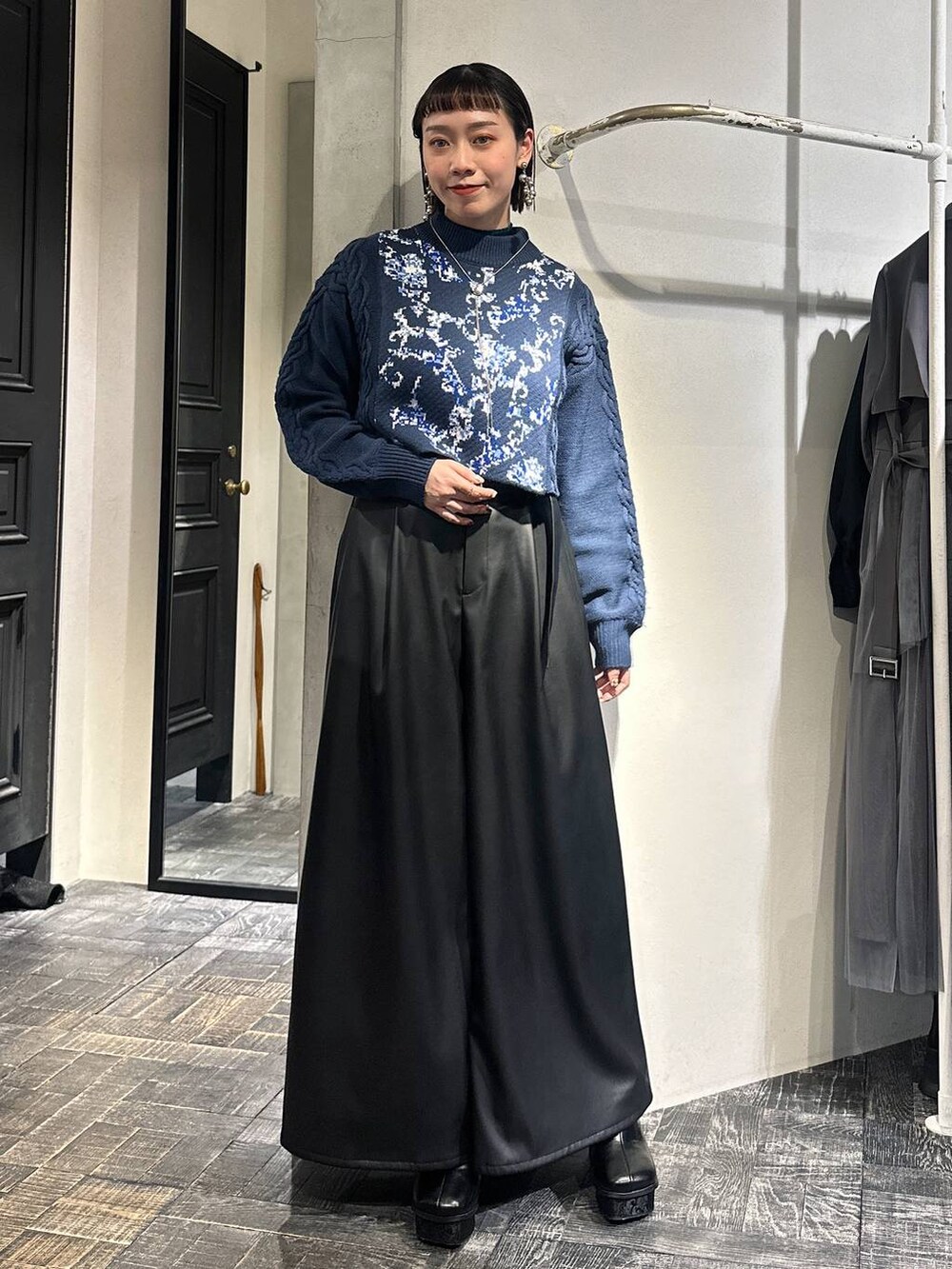 ブルー系のニット/セーター、ブラック系のその他パンツ、ブラック系のブーツを着用したレディースの冬コーディネートの6枚目の写真