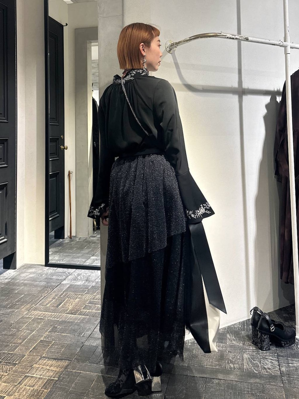 ブラック系のブーツ、ブラック系のシャツ/ブラウス、ブラック系のスカートを着用したレディースの冬コーディネートの4枚目の写真