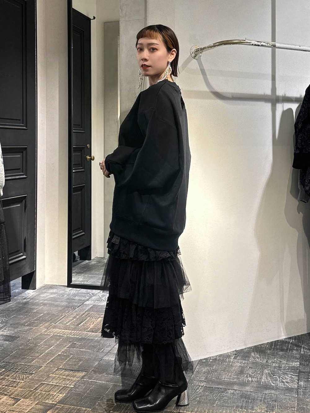 ブラック系のブーツ、ブラック系のショルダーバッグ、ブラック系のスウェットを着用したレディースの秋コーディネートの3枚目の写真