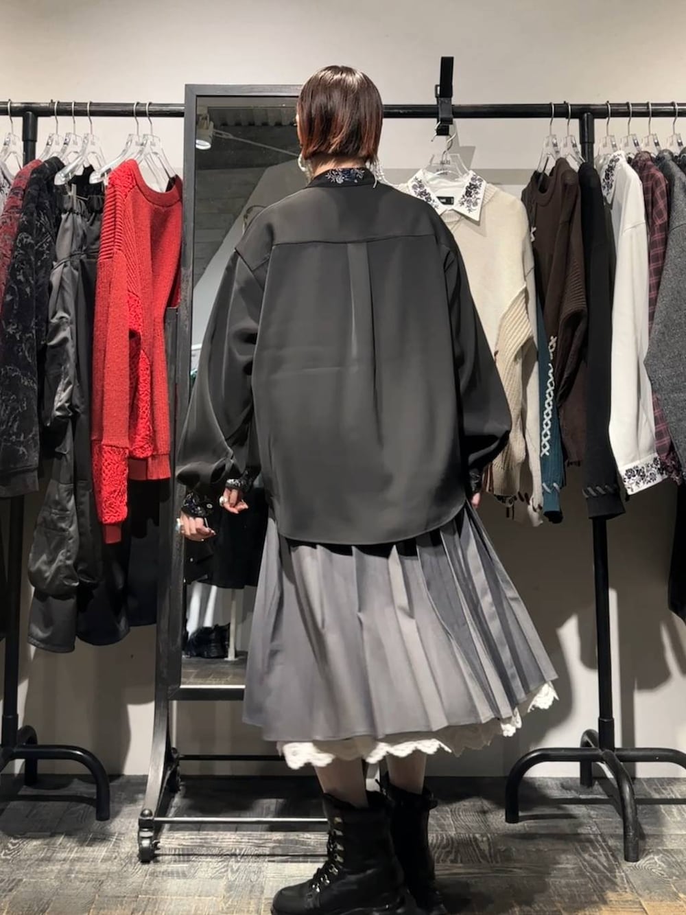 グレー系のスカート、ブラック系のシャツ/ブラウス、ブラック系のブーツを着用したレディースの秋コーディネートの2枚目の写真