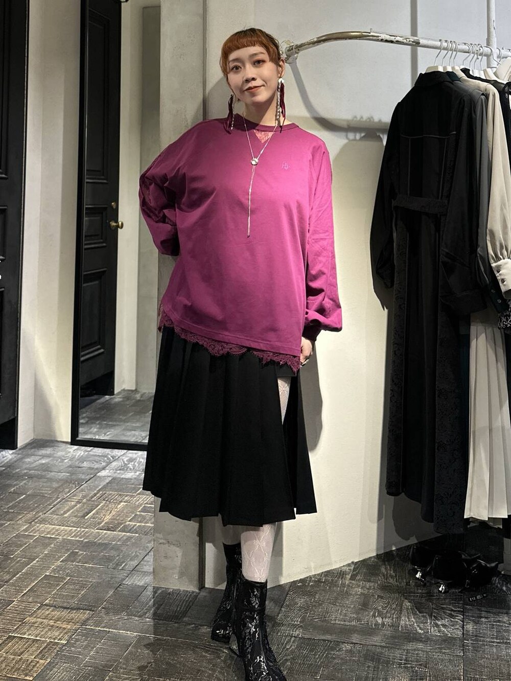 ブラック系のブーツ、ブラック系のスカート、ピンク系のTシャツ/カットソーを着用したレディースの冬コーディネートの5枚目の写真