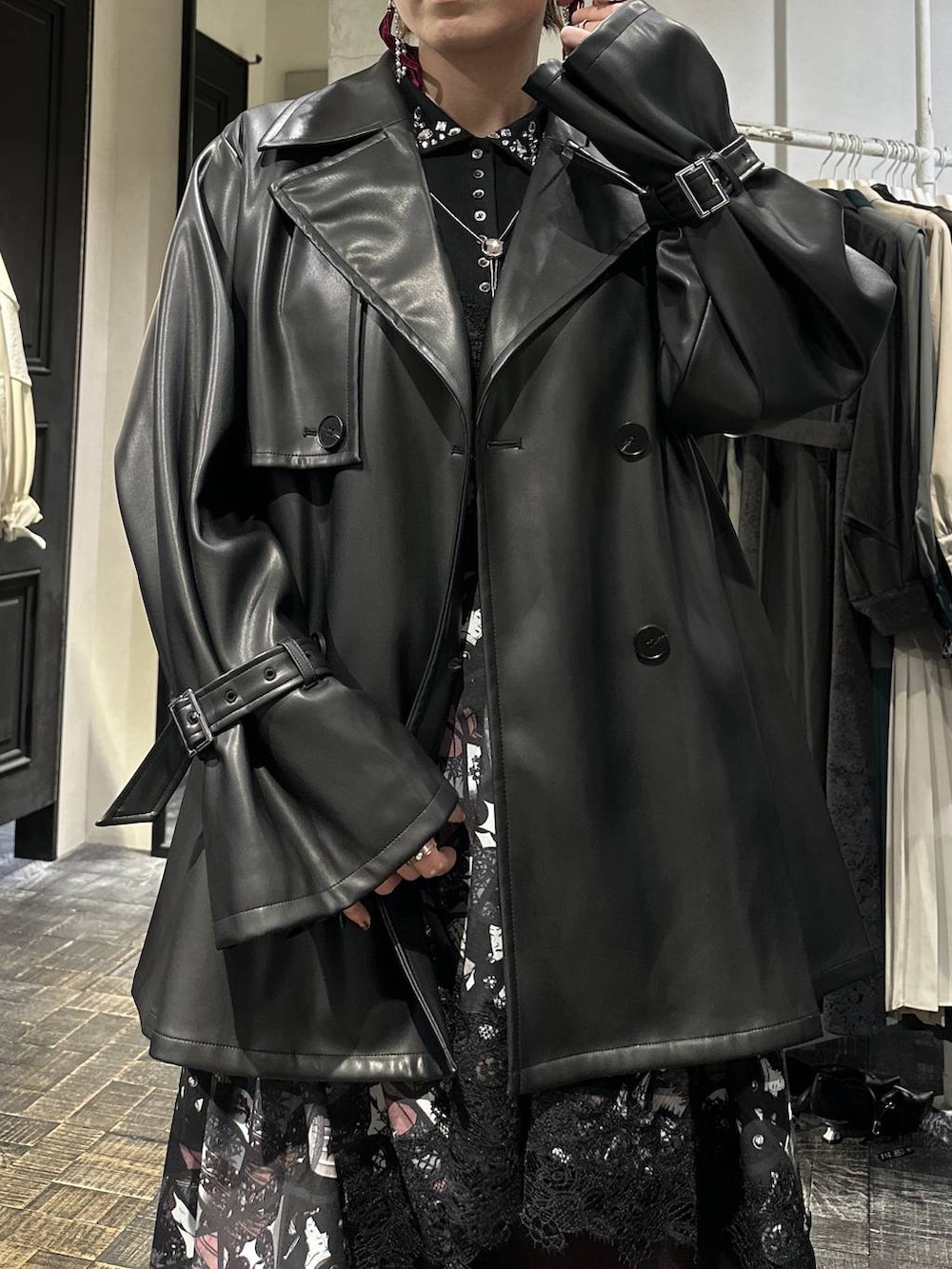 ブラック系のブーツ、ブラック系のトレンチコート、ブラック系のTシャツ/カットソーを着用したレディースの冬コーディネートの7枚目の写真