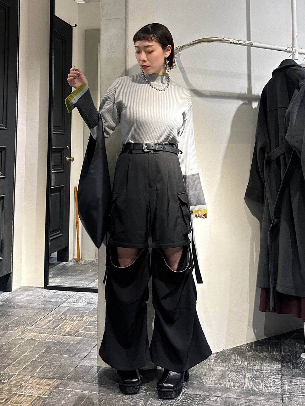 ブラック系のカーゴパンツ、ブラック系のトートバッグ、グレー系のニット/セーターを着用したレディースの冬コーディネートの2枚目の写真