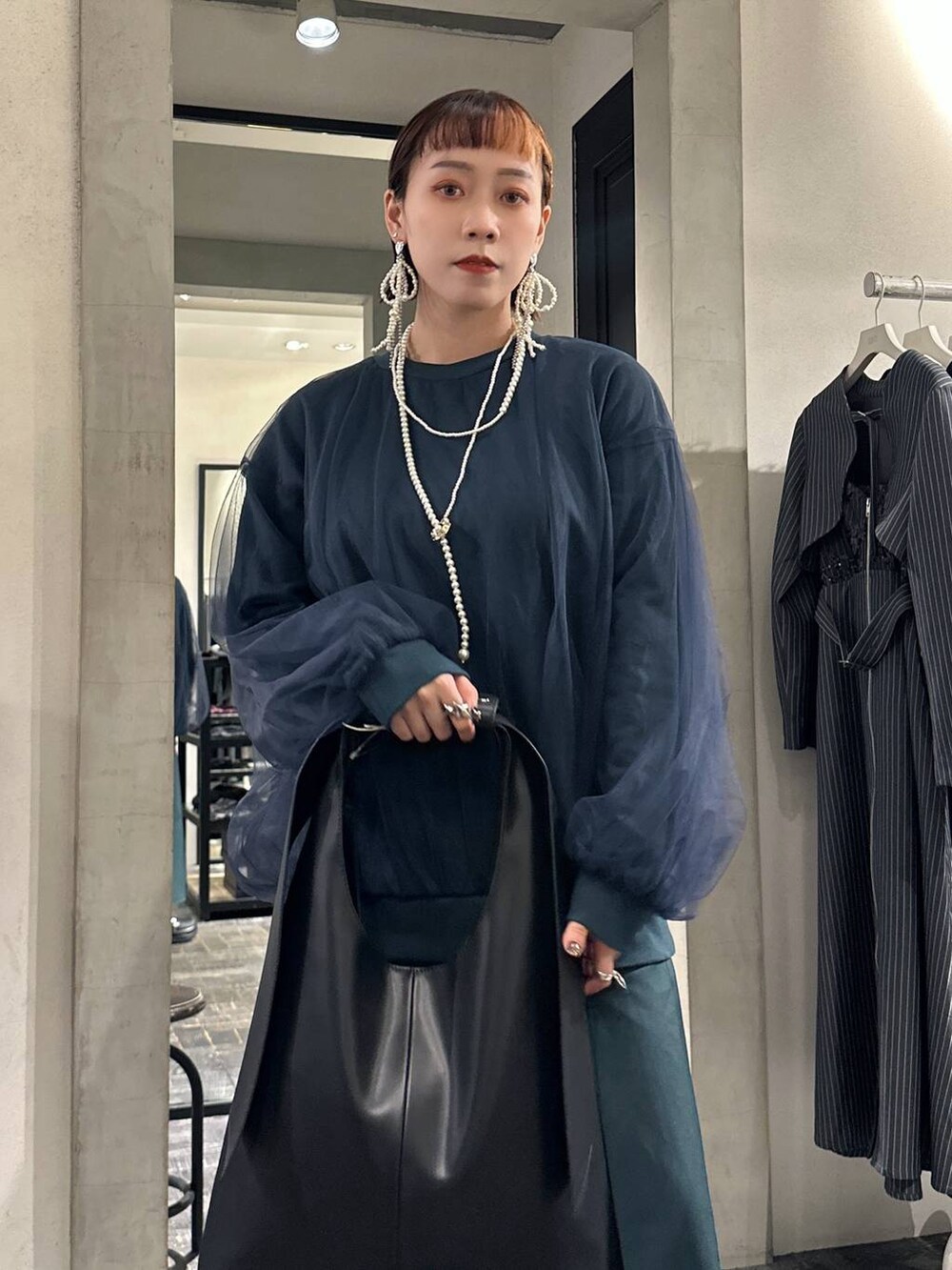 ブラック系のブーツ、ブラック系のトートバッグ、グリーン系のスウェットを着用したレディースの夏コーディネートの2枚目の写真