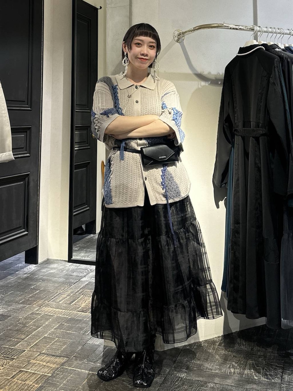 ブラック系のブーツ、ブラック系のボディバッグ/ウエストポーチ、ブラック系のスカートを着用したレディースの春コーディネートの5枚目の写真