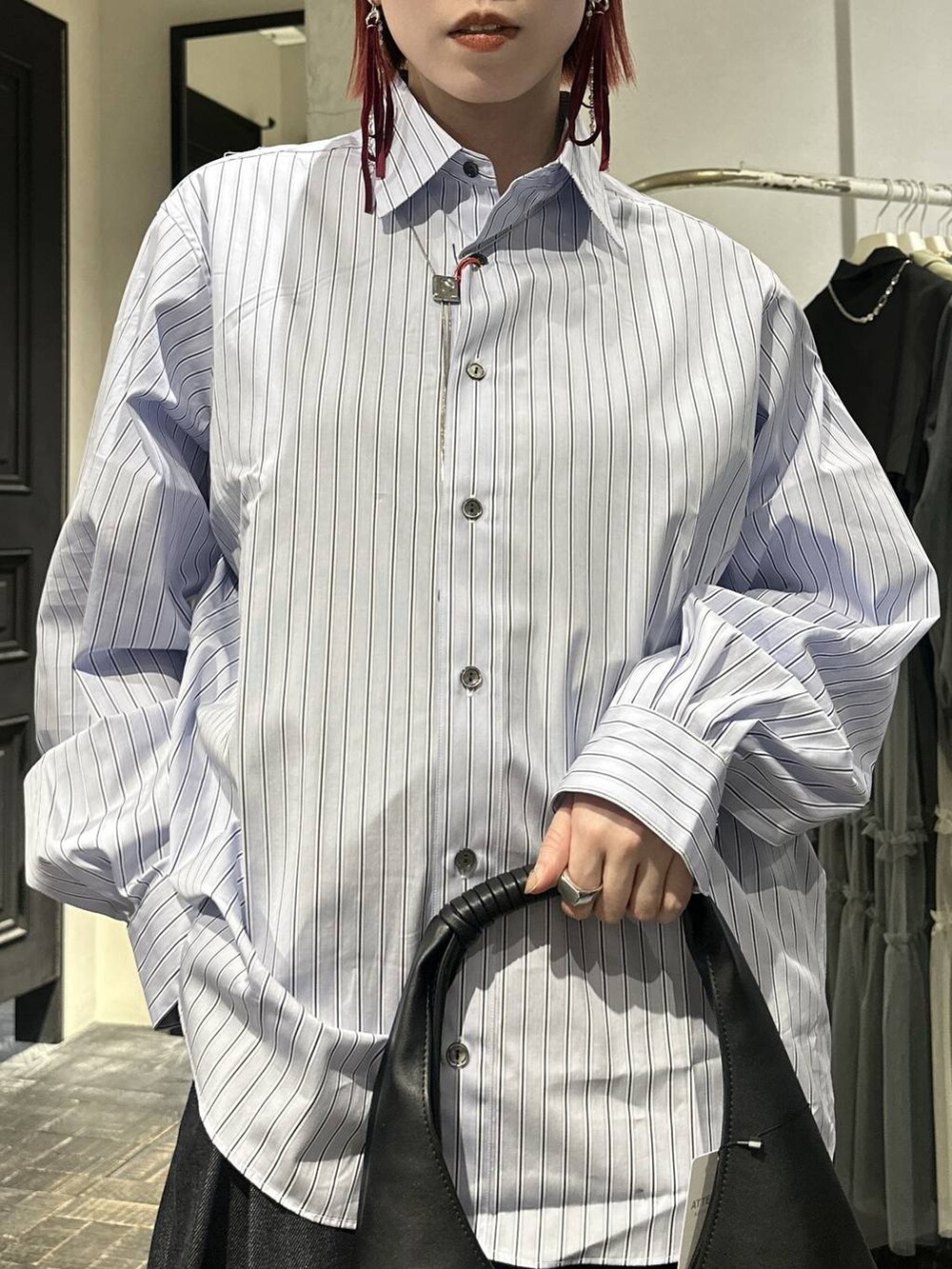 ブラック系のローファー、グレー系のスラックス、シルバー系のネックレスを着用したレディースの春コーディネートの6枚目の写真