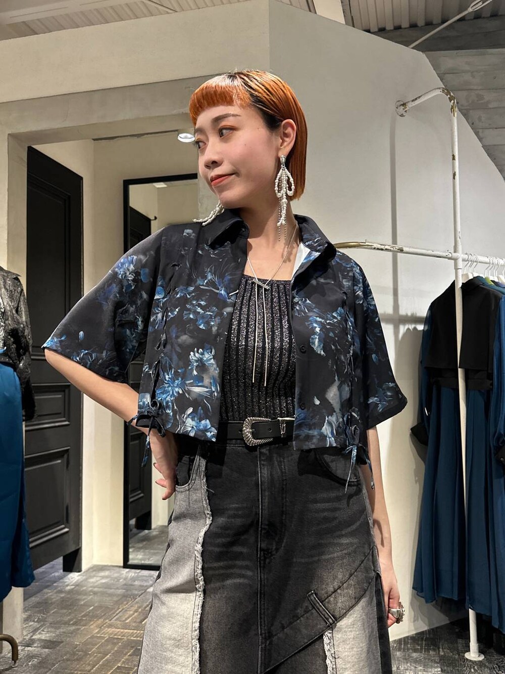 ブラック系のタンクトップ、ブラック系のサンダル、ブラック系のデニムスカートを着用したレディースの春コーディネートの2枚目の写真