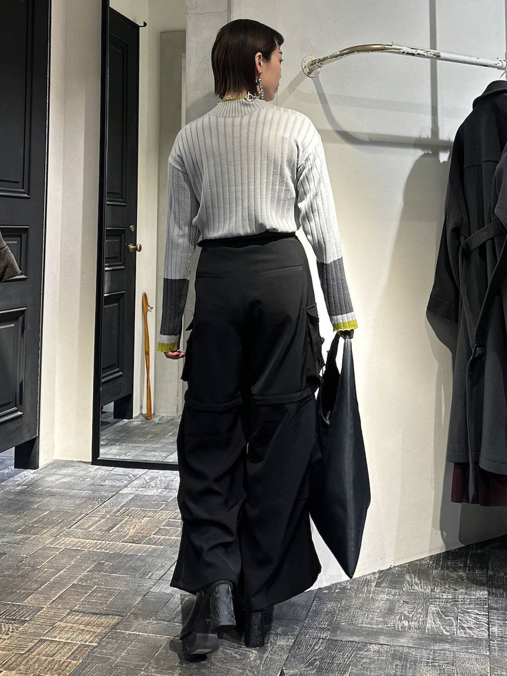 ブラック系のカーゴパンツ、ブラック系のトートバッグ、グレー系のニット/セーターを着用したレディースの冬コーディネートの4枚目の写真