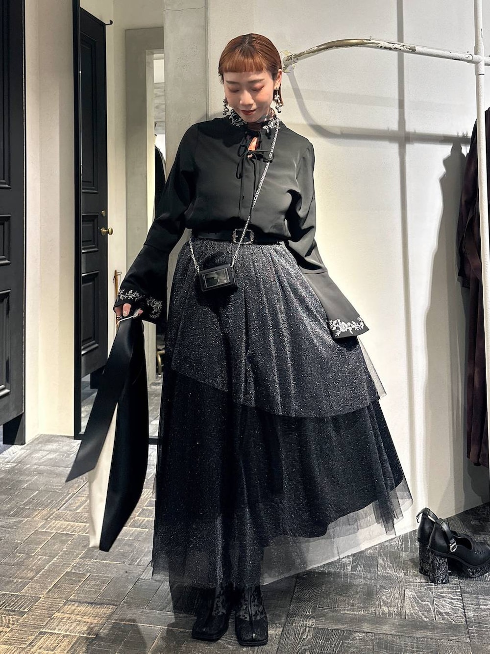 ブラック系のブーツ、ブラック系のシャツ/ブラウス、ブラック系のスカートを着用したレディースの冬コーディネートの3枚目の写真