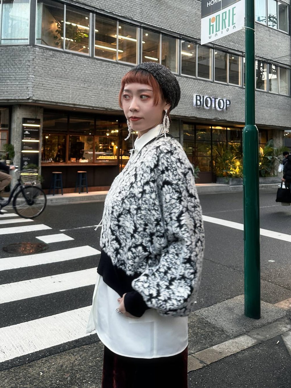 ブラック系のニット/セーター、レッド系のデニムパンツ、ホワイト系のシャツ/ブラウスを着用したレディースの秋コーディネートの4枚目の写真