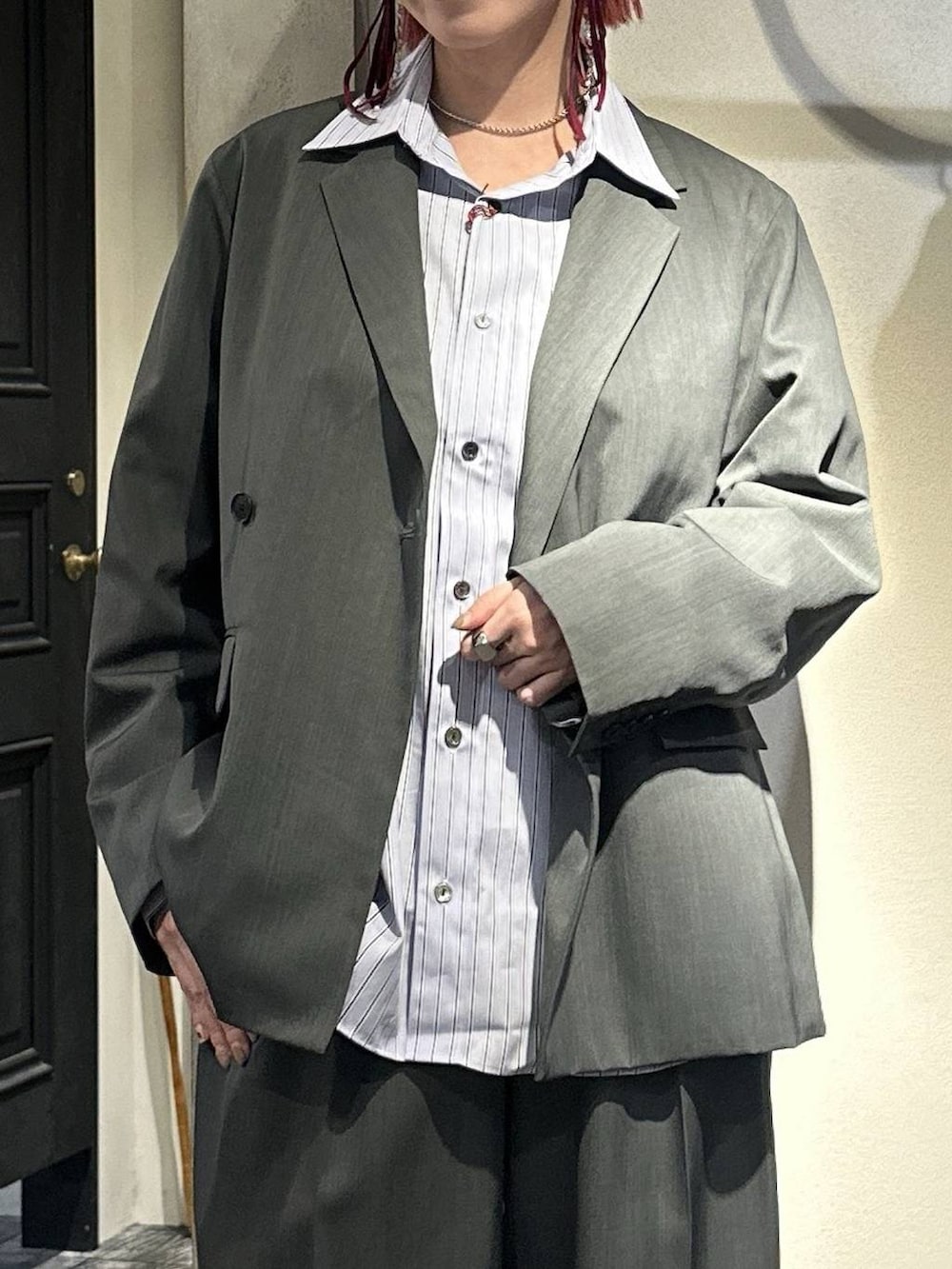 ブラック系のローファー、グレー系のスラックス、シルバー系のネックレスを着用したレディースの春コーディネートの2枚目の写真