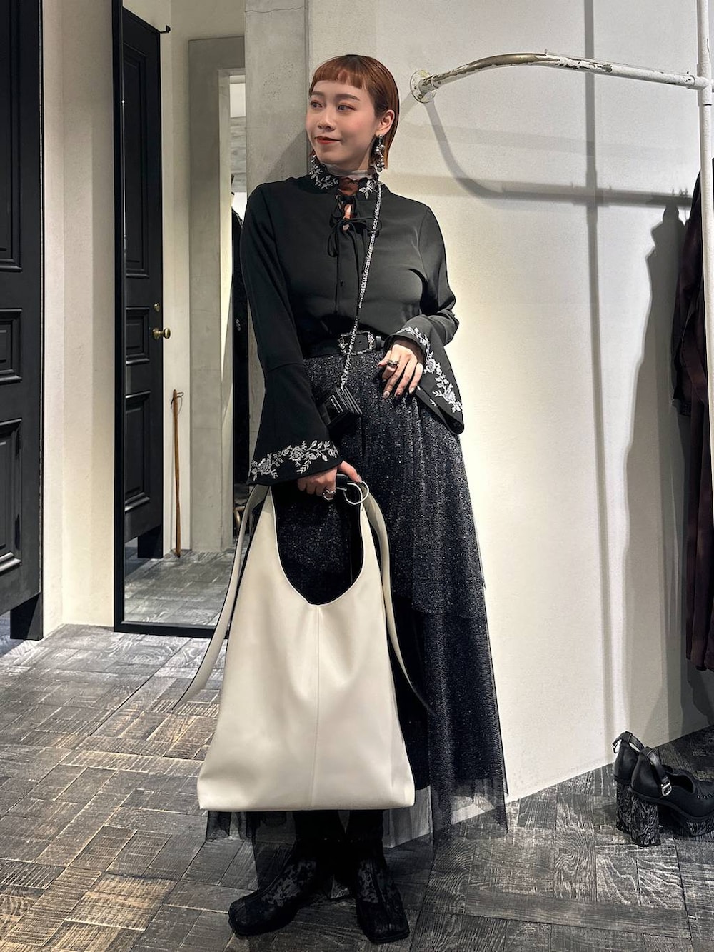 ブラック系のブーツ、ブラック系のシャツ/ブラウス、ブラック系のスカートを着用したレディースの冬コーディネートの7枚目の写真