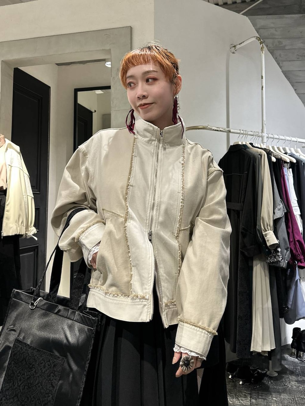 ブラック系のトートバッグ、ブラック系のブーツ、ブラック系のスカートを着用したレディースの冬コーディネートの2枚目の写真