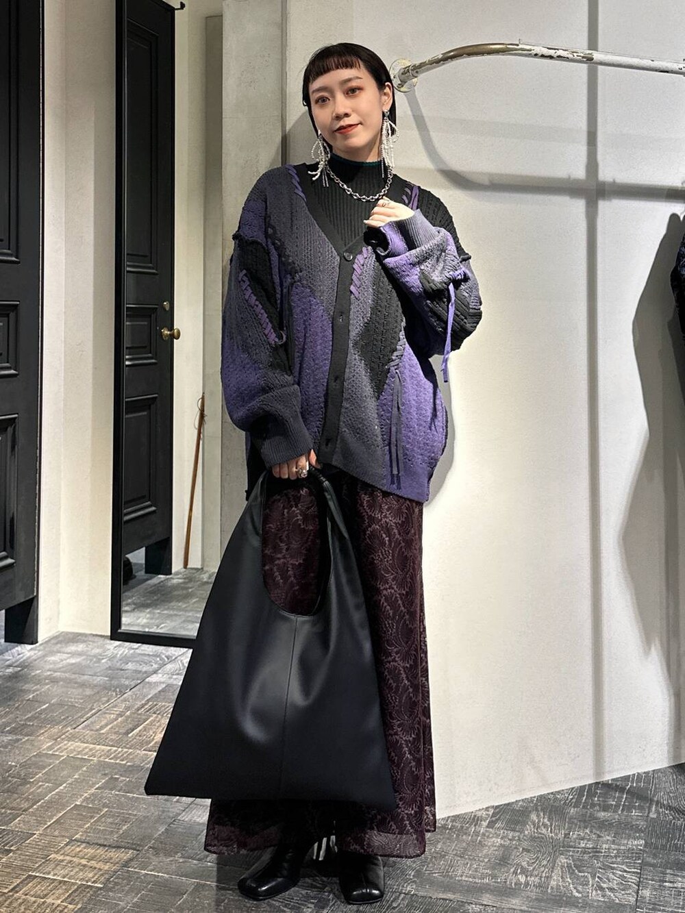 ブラック系のカーディガン/ボレロ、ブラック系のトートバッグ、ブラック系のブーツを着用したレディースの秋コーディネートの2枚目の写真