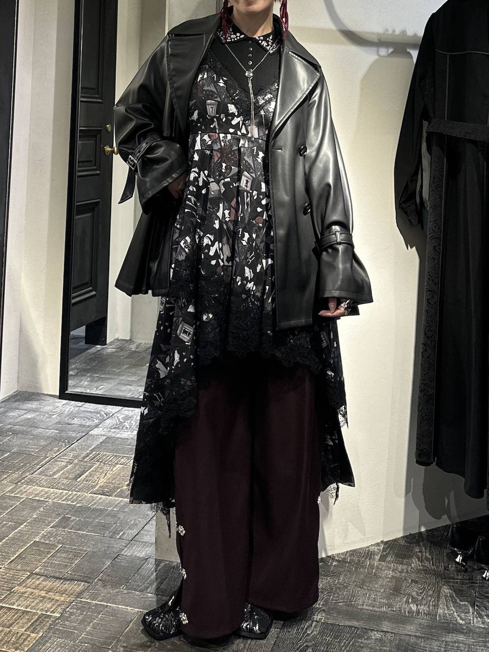 ブラック系のブーツ、ブラック系のトレンチコート、ブラック系のTシャツ/カットソーを着用したレディースの冬コーディネートの5枚目の写真