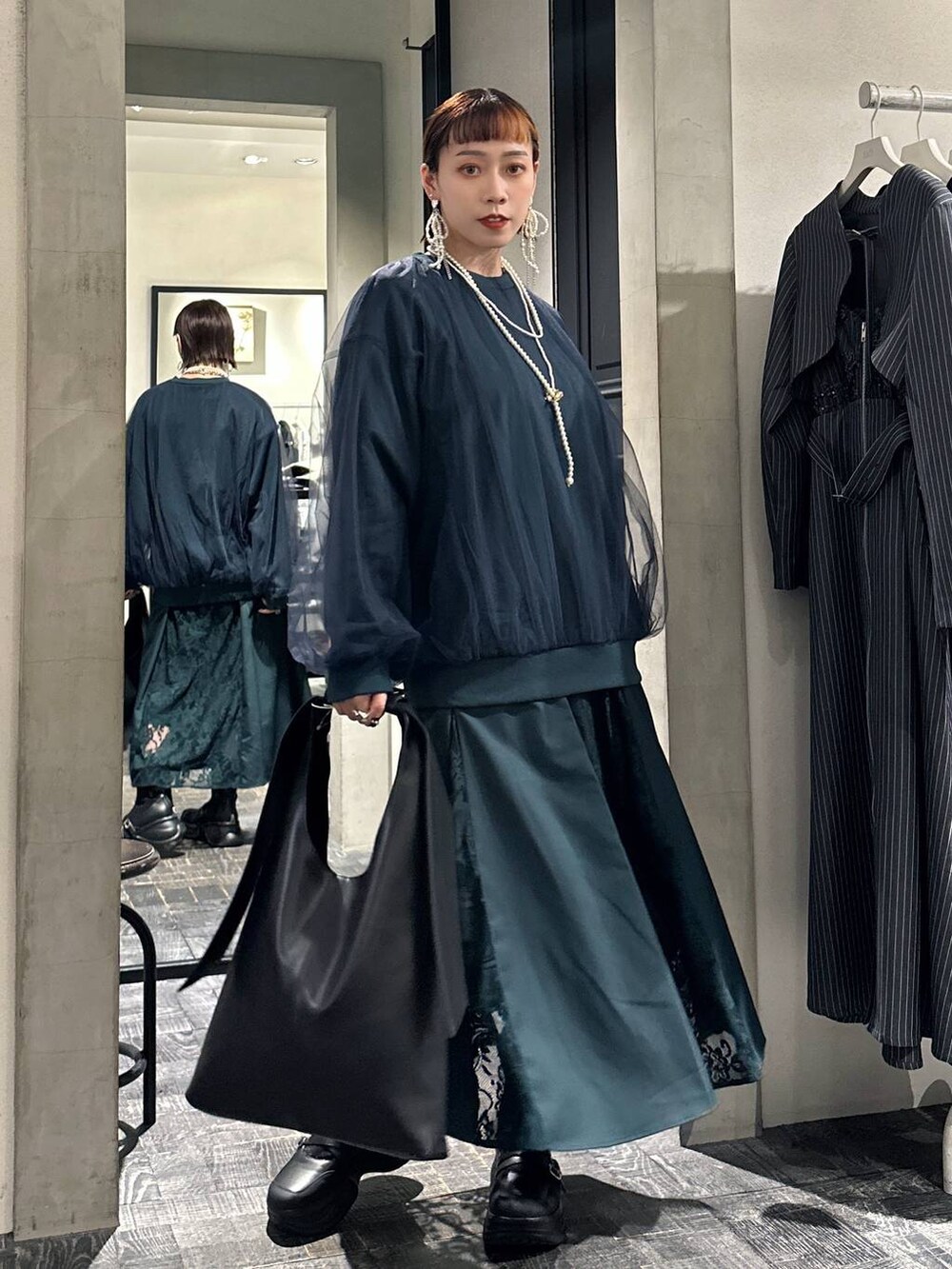 ブラック系のブーツ、ブラック系のトートバッグ、グリーン系のスウェットを着用したレディースの夏コーディネートの5枚目の写真