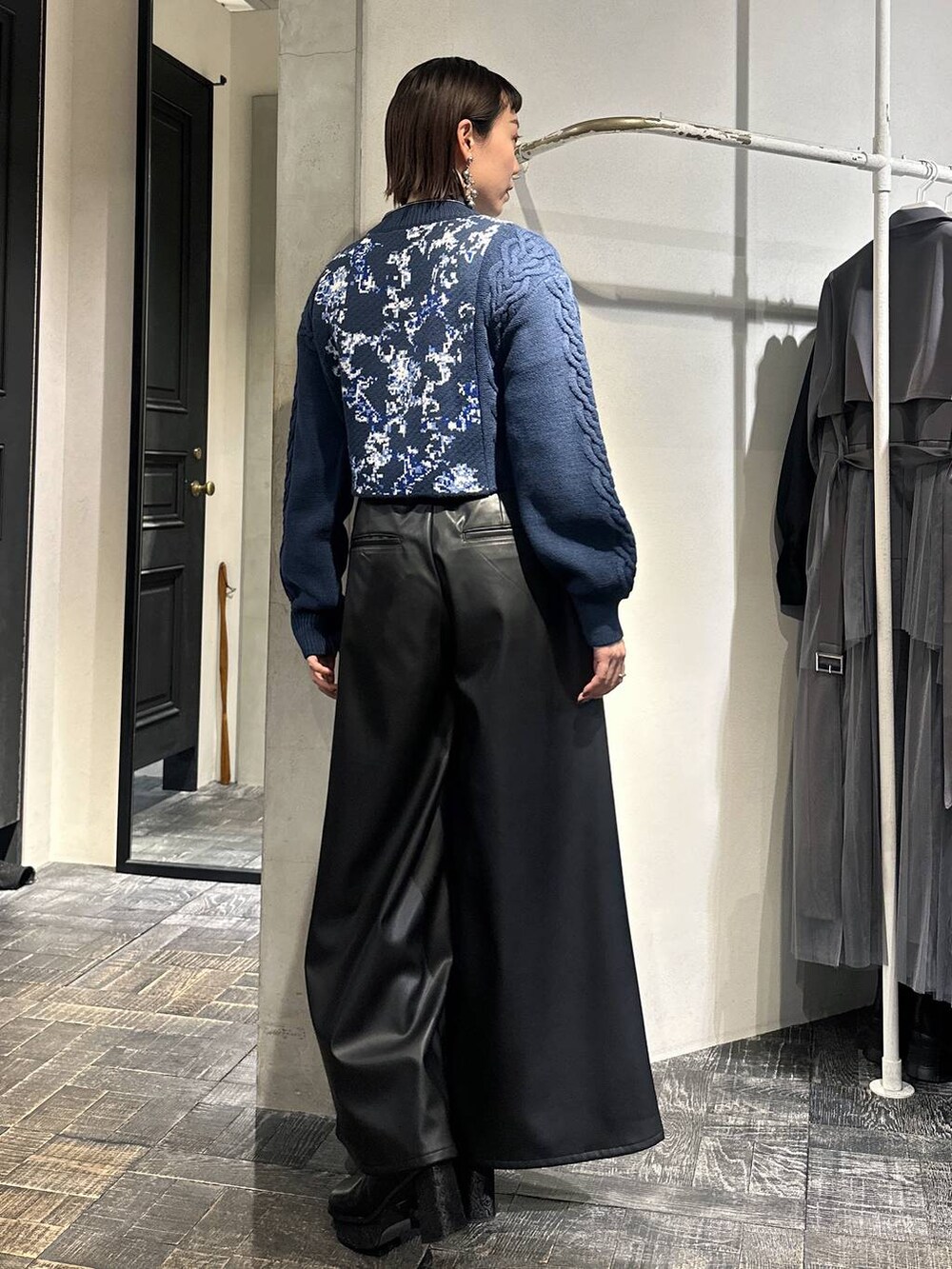 ブルー系のニット/セーター、ブラック系のその他パンツ、ブラック系のブーツを着用したレディースの冬コーディネートの4枚目の写真