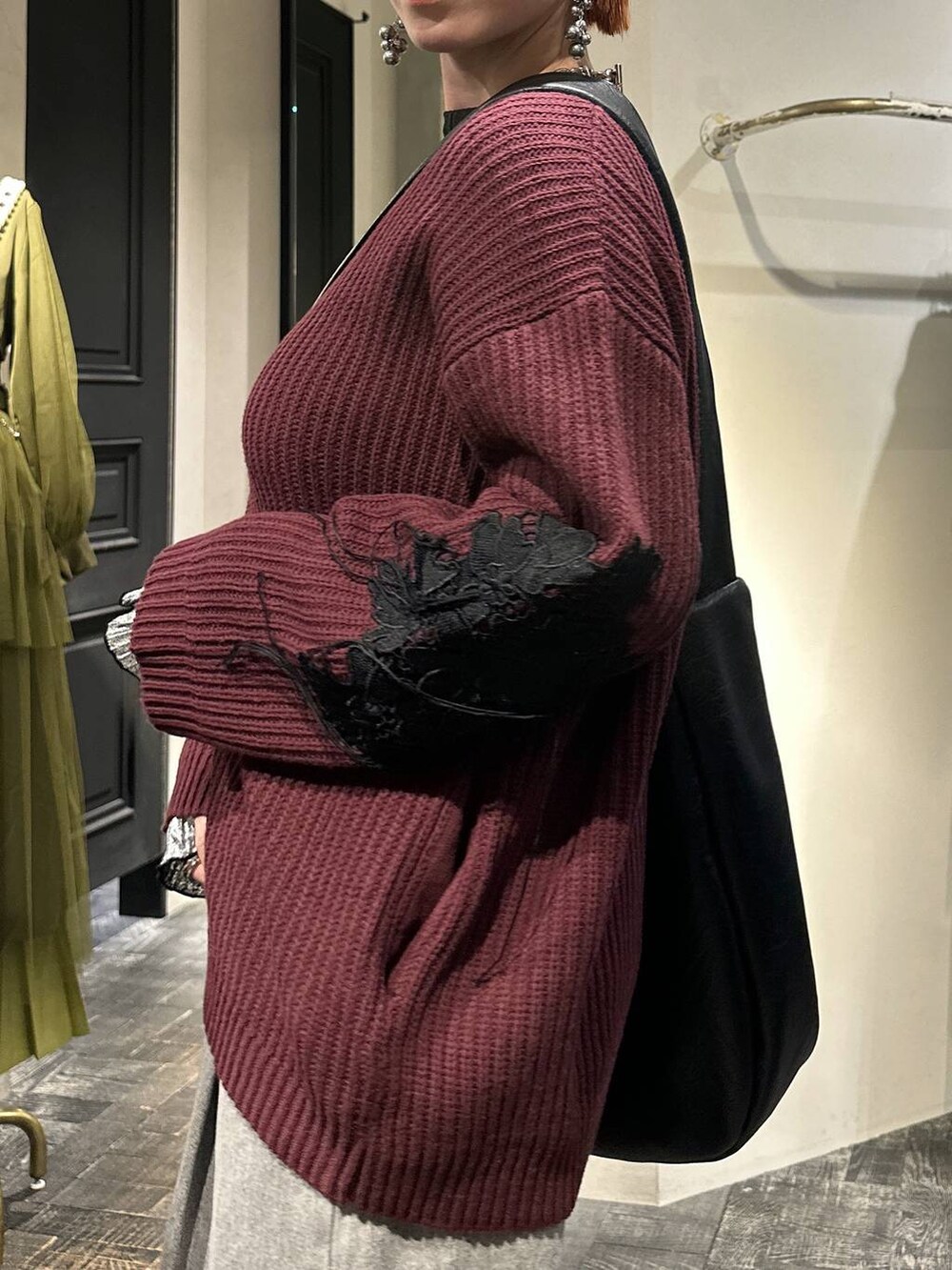 ブラック系のTシャツ/カットソー、レッド系のカーディガン/ボレロ、ブラック系のショルダーバッグを着用したレディースの冬コーディネートの4枚目の写真