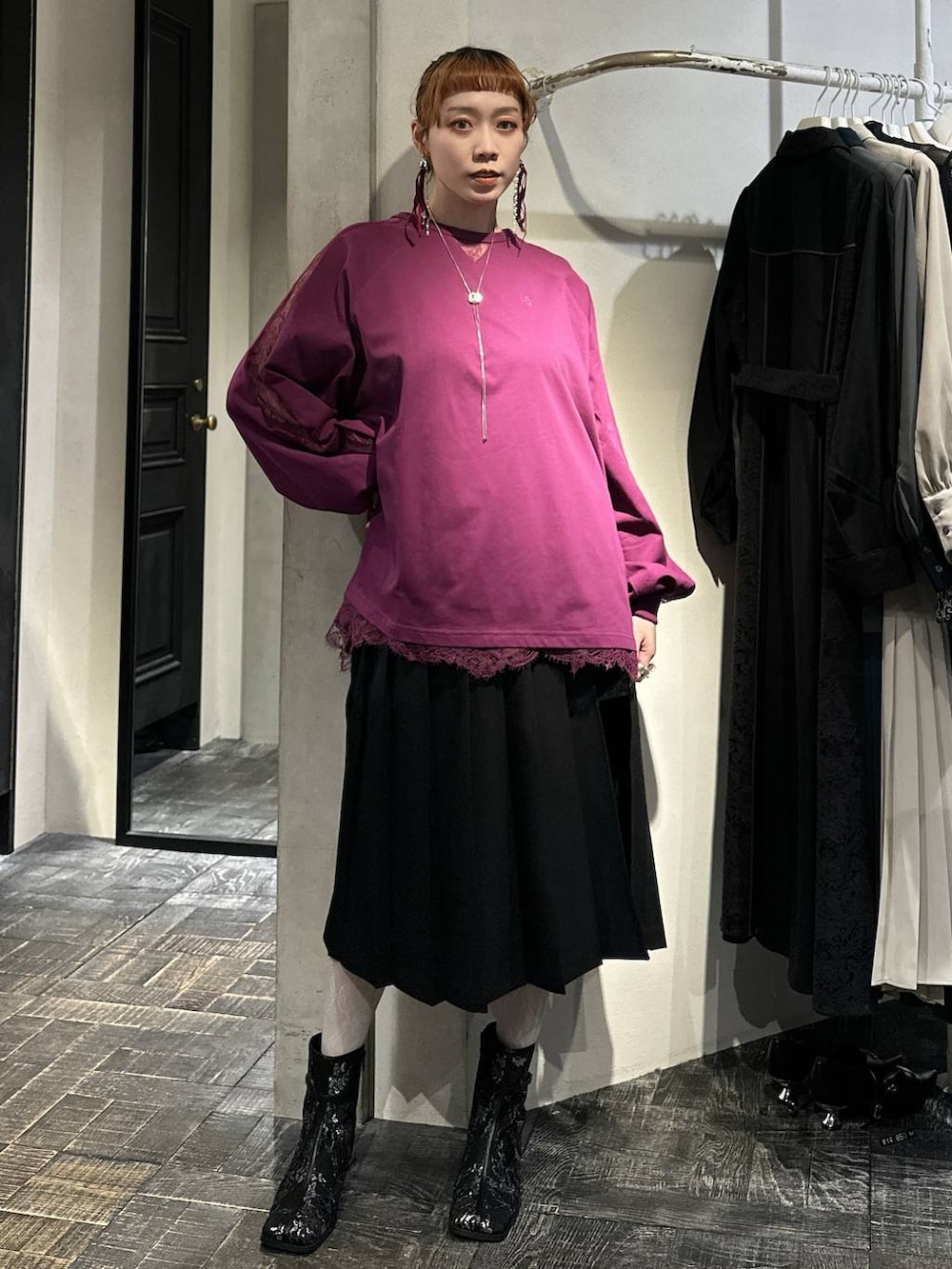 ブラック系のブーツ、ブラック系のスカート、ピンク系のTシャツ/カットソーを着用したレディースの冬コーディネートの4枚目の写真