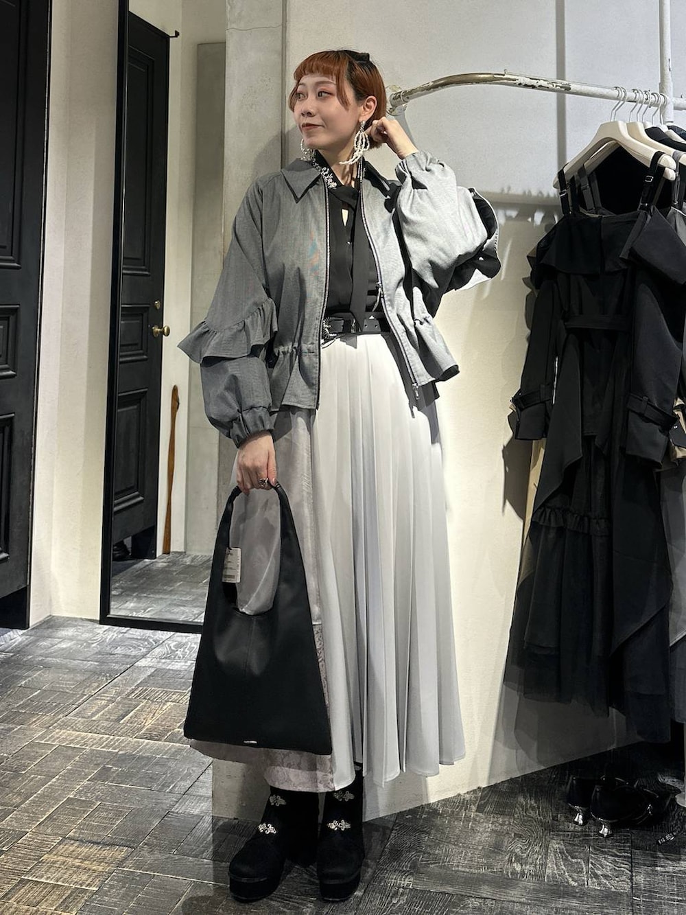 ブラック系のトートバッグ、ブラック系のブーツ、ブラック系のシャツ/ブラウスを着用したレディースの冬コーディネートの4枚目の写真