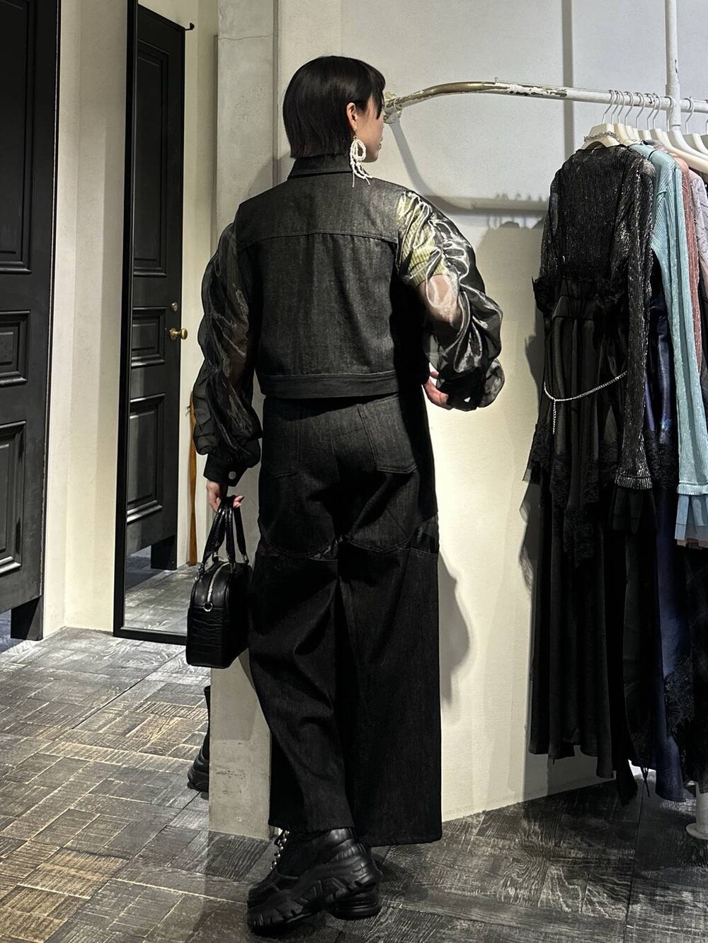 ブラック系のスニーカー、ブラック系のブルゾン、ブラック系のデニムパンツを着用したレディースの春コーディネートの5枚目の写真