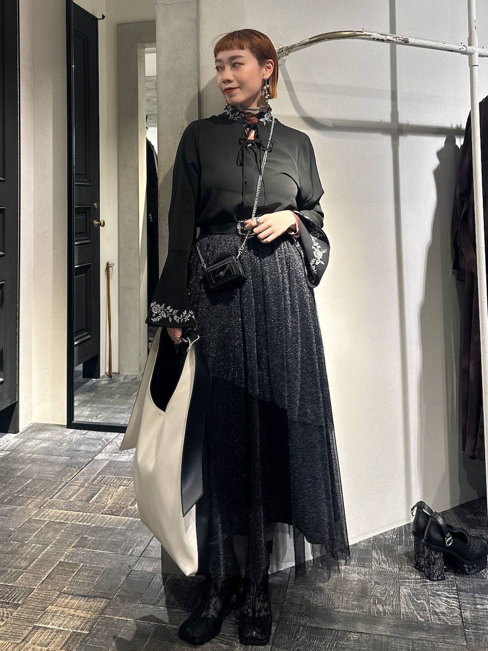 ブラック系のブーツ、ブラック系のシャツ/ブラウス、ブラック系のスカートを着用したレディースの冬コーディネートの2枚目の写真