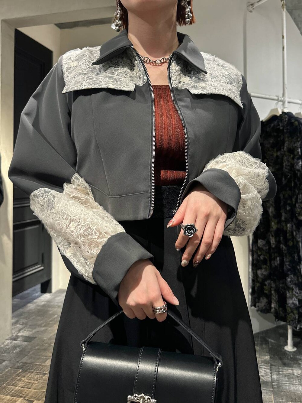 オレンジ系のタンクトップ、ブラック系のショルダーバッグ、ブラック系のスニーカーを着用したレディースの冬コーディネートの5枚目の写真