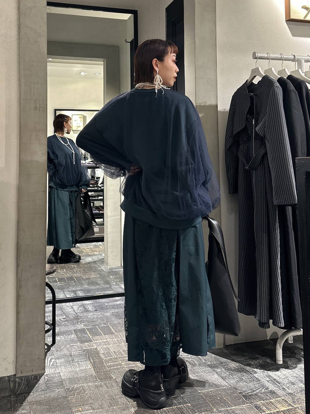 ブラック系のブーツ、ブラック系のトートバッグ、グリーン系のスウェットを着用したレディースの夏コーディネートの4枚目の写真