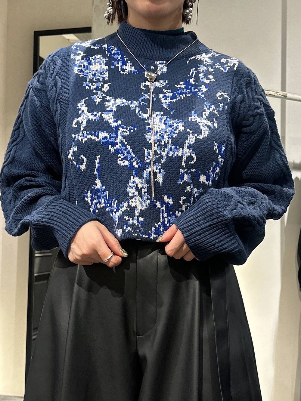 ブルー系のニット/セーター、ブラック系のその他パンツ、ブラック系のブーツを着用したレディースの冬コーディネートの5枚目の写真
