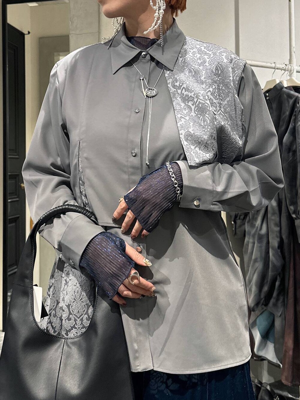 ブラック系のトートバッグ、ブルー系のTシャツ/カットソー、グレー系のシャツ/ブラウスを着用したレディースの冬コーディネートの5枚目の写真