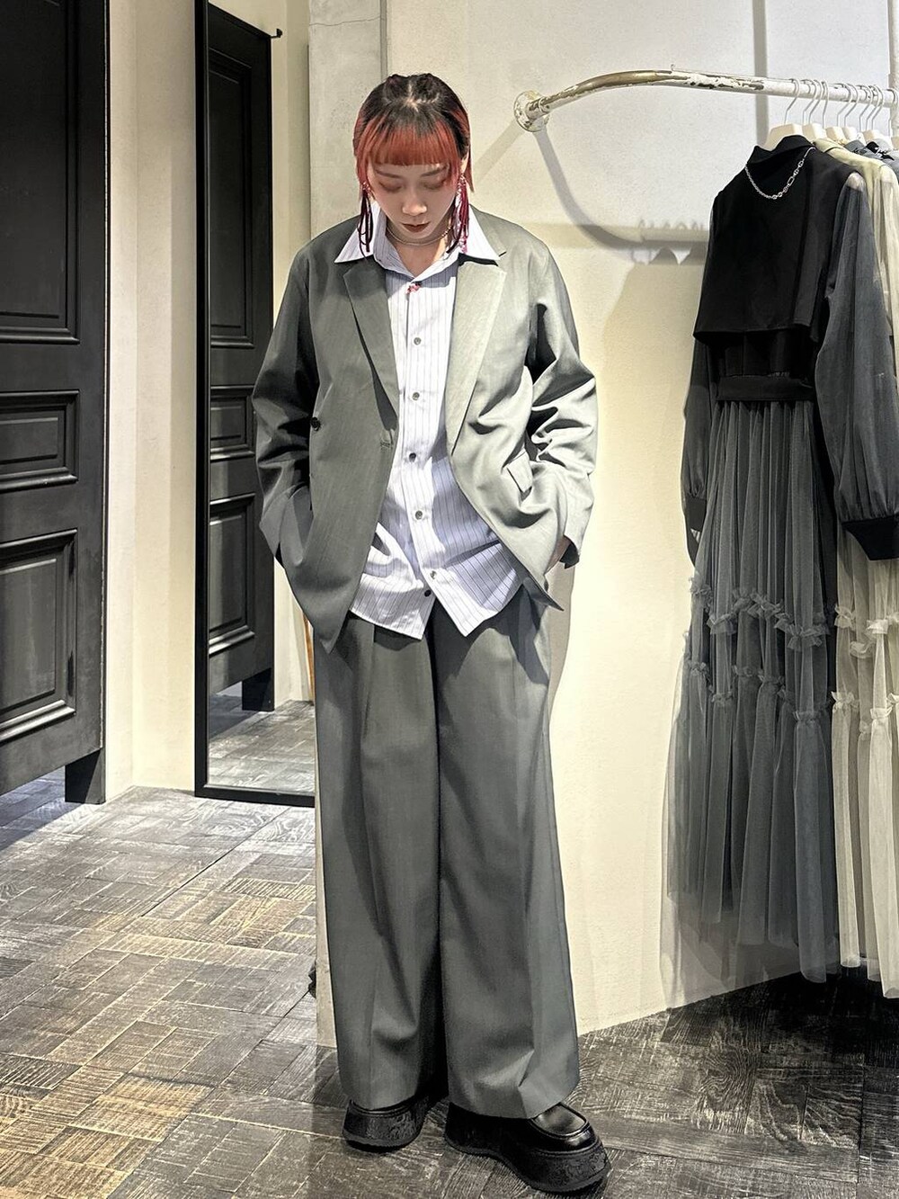 ブラック系のローファー、グレー系のスラックス、シルバー系のネックレスを着用したレディースの春コーディネートの4枚目の写真