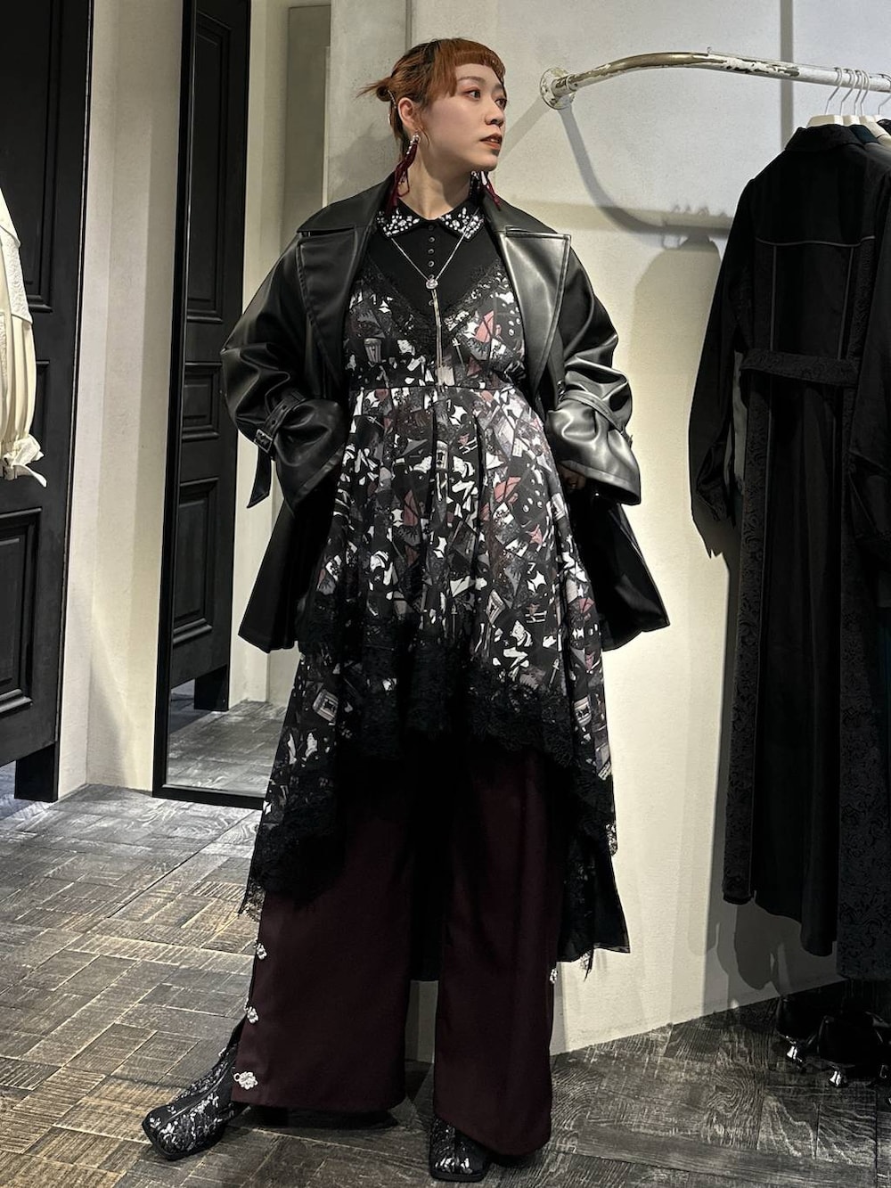 ブラック系のブーツ、ブラック系のトレンチコート、ブラック系のTシャツ/カットソーを着用したレディースの冬コーディネートの3枚目の写真