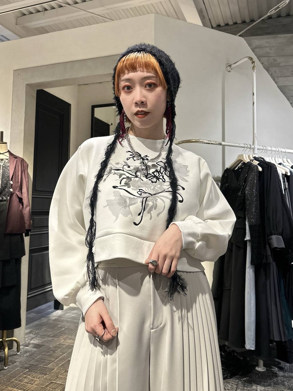 ホワイト系のスウェット、ブラック系のブーツ、ホワイト系のスラックスを着用したレディースの冬コーディネートの2枚目の写真