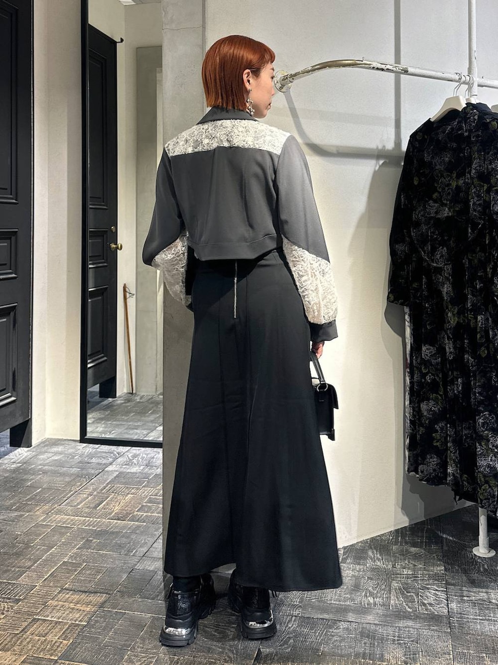 オレンジ系のタンクトップ、ブラック系のショルダーバッグ、ブラック系のスニーカーを着用したレディースの冬コーディネートの4枚目の写真