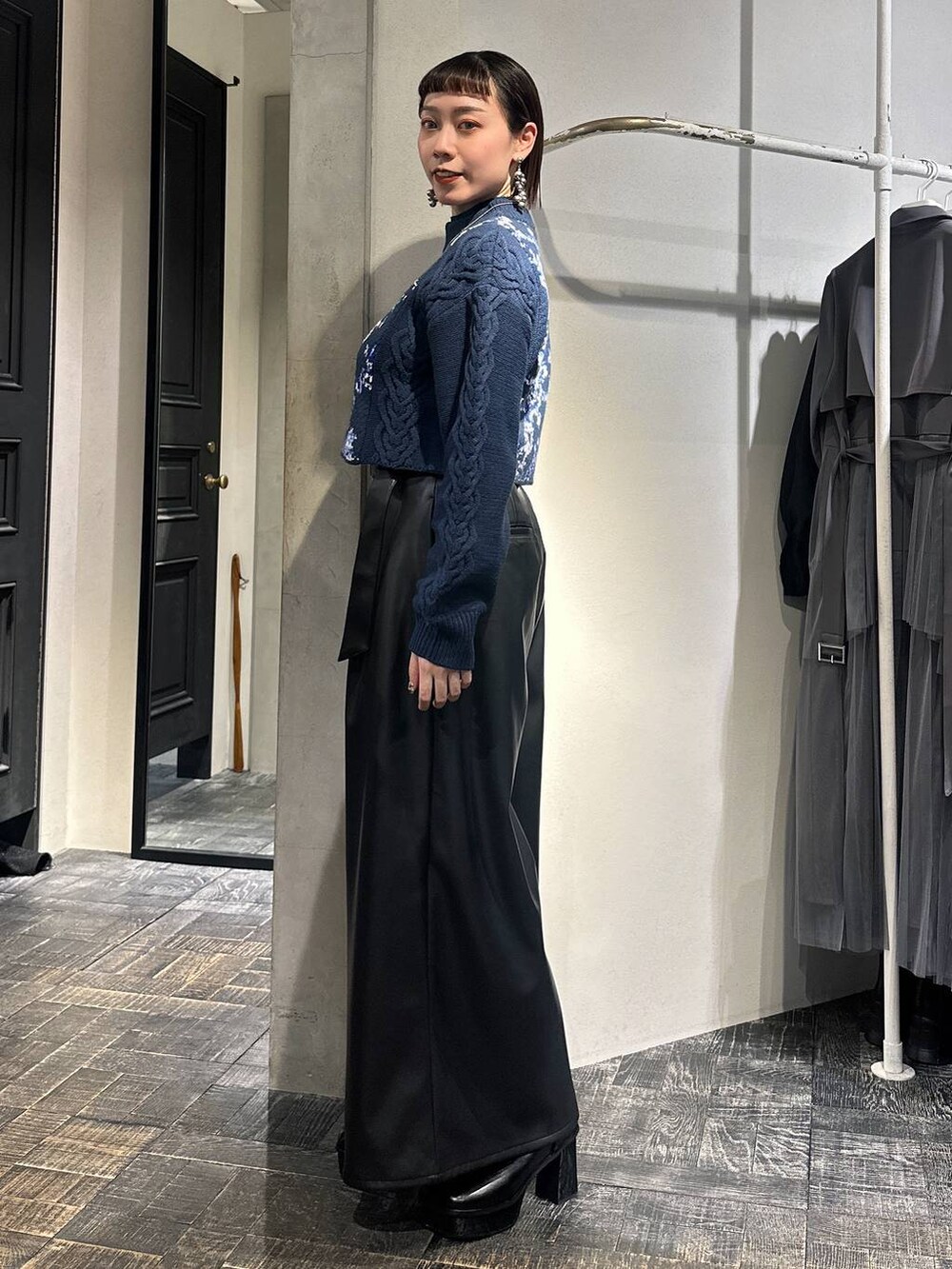 ブルー系のニット/セーター、ブラック系のその他パンツ、ブラック系のブーツを着用したレディースの冬コーディネートの3枚目の写真